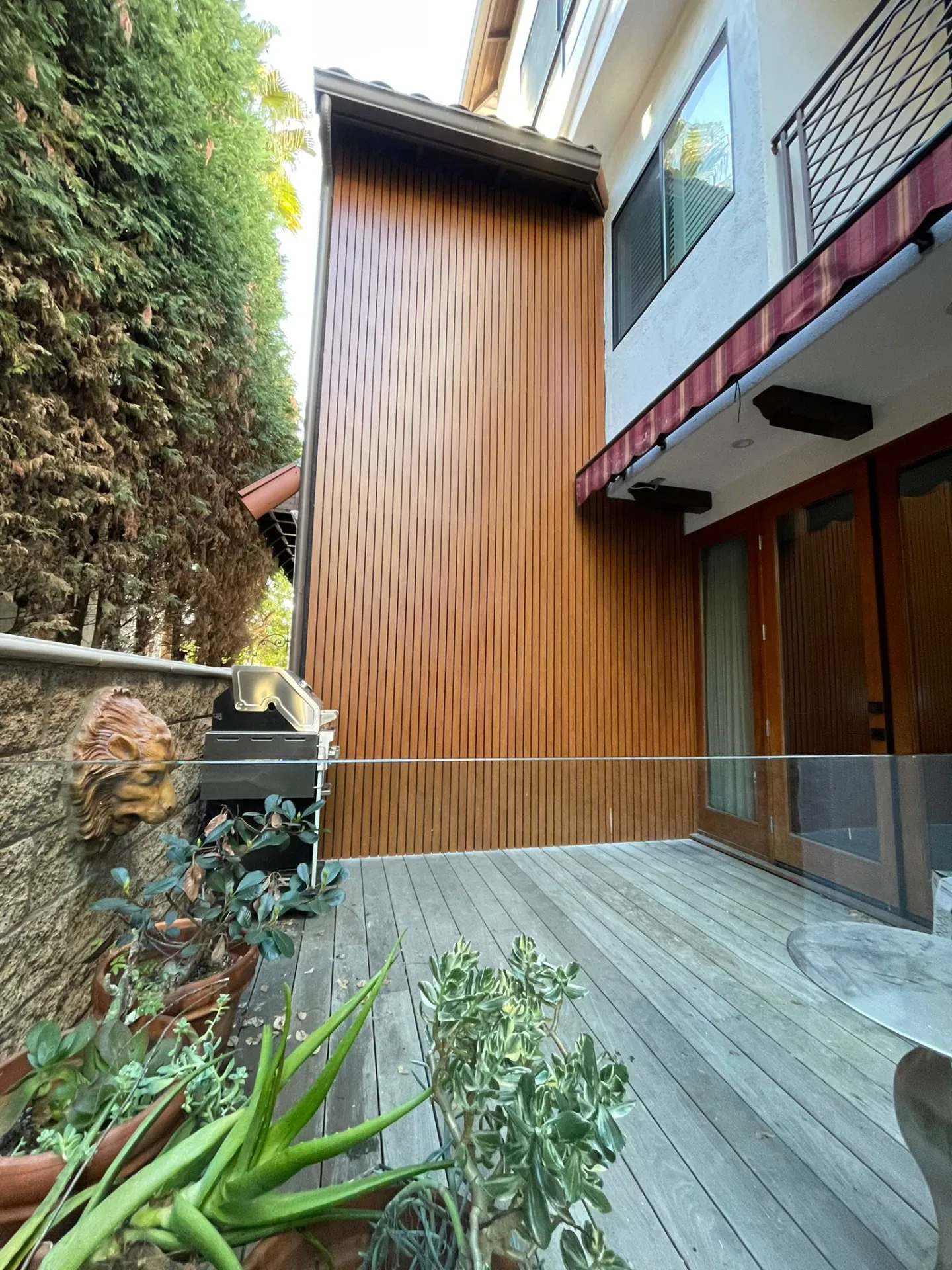 Teak-tone wood-grain aluminum cladding still crisp years after installation
