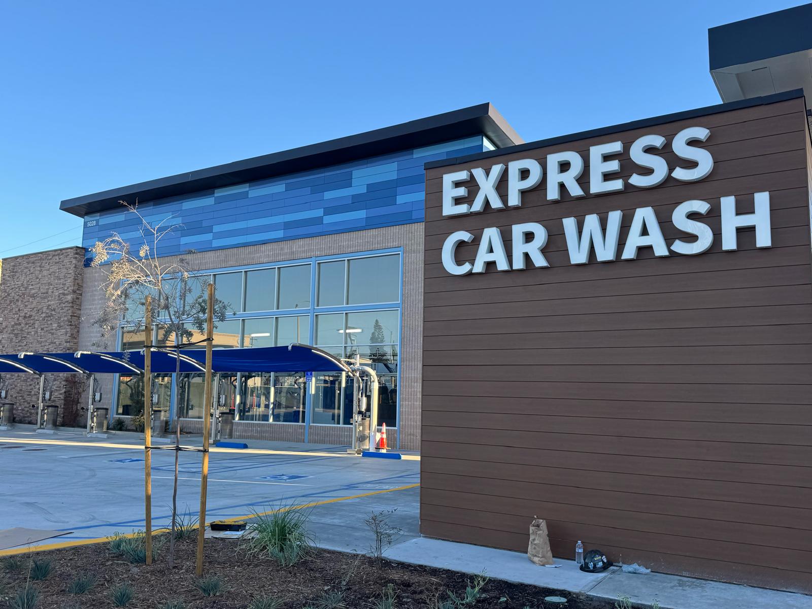Wood-look and blue aluminum exterior cladding on an Express Car Wash commercial building