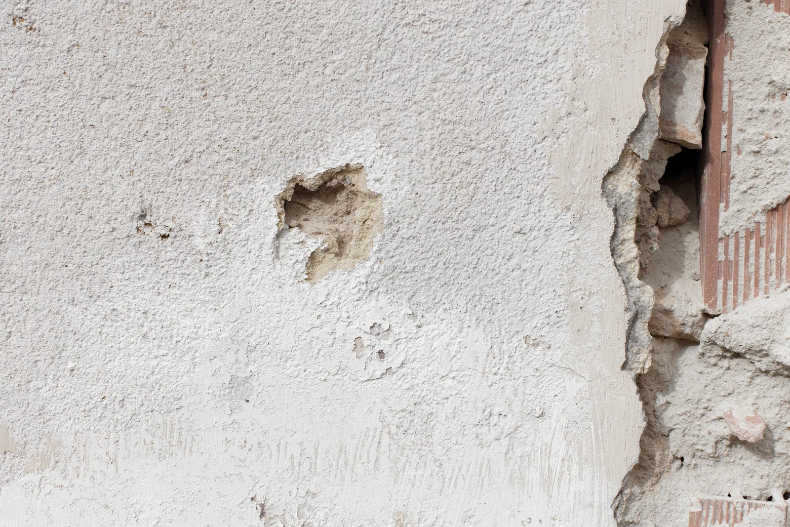 Cracked and crumbling cement-based wall cladding, the brittleness aluminum cladding avoids