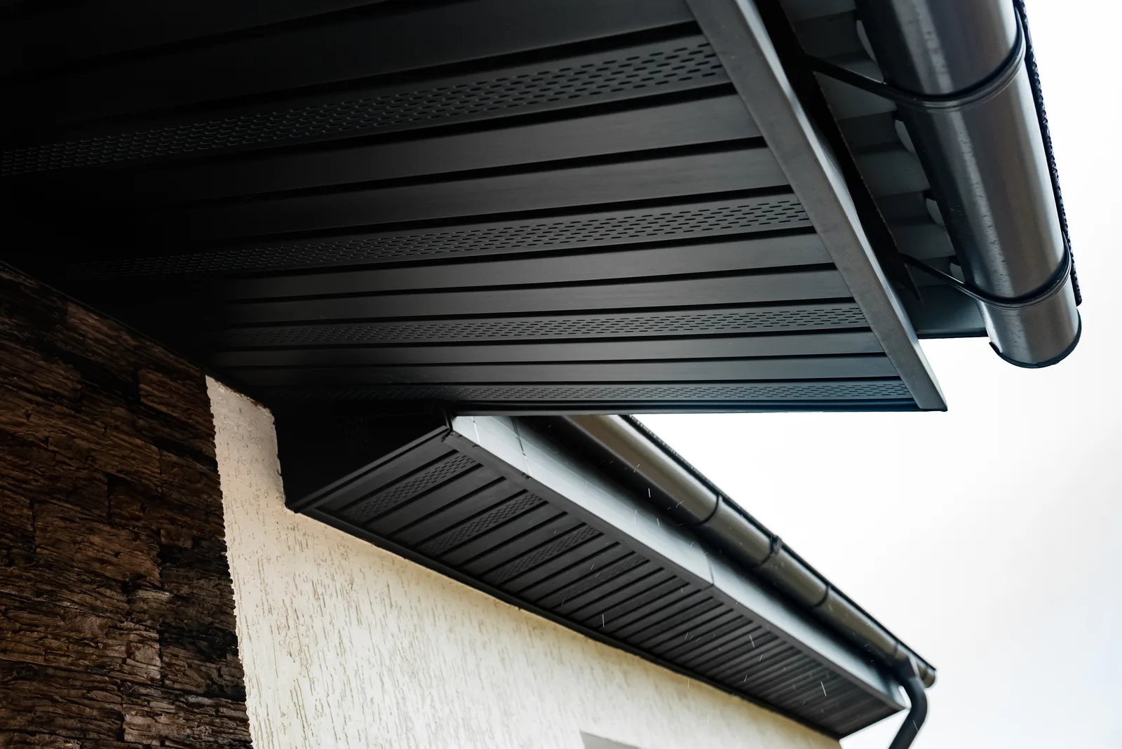 Close-up of a vented aluminum soffit panel showing the perforations that ventilate the attic